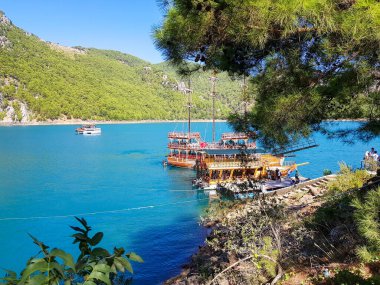 Güneşli, bulutsuz bir günde, dağların arka planına karşı deniz manzarası.