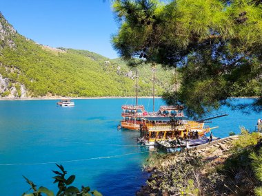 Güneşli, bulutsuz bir günde, dağların arka planına karşı deniz manzarası.
