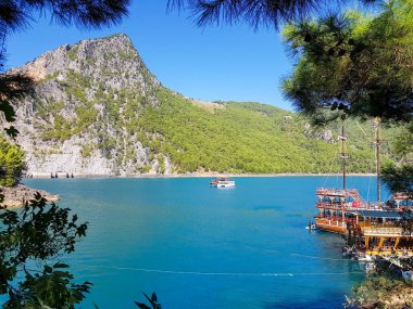 Güneşli, bulutsuz bir günde, dağların arka planına karşı deniz manzarası.