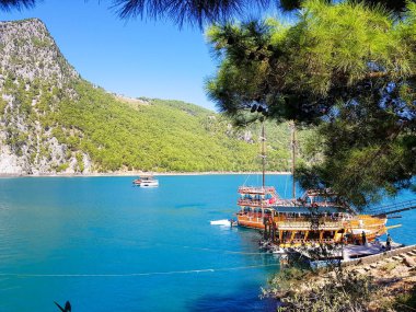 Güneşli, bulutsuz bir günde, dağların arka planına karşı deniz manzarası.