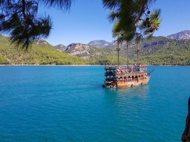 Güneşli, bulutsuz bir günde, dağların arka planına karşı deniz manzarası.