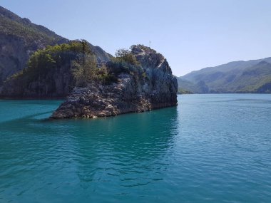 Güneşli, bulutsuz bir günde, dağların arka planına karşı deniz manzarası.