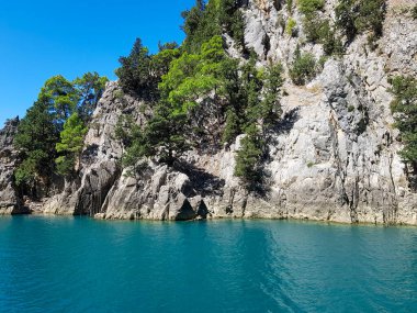 Güneşli, bulutsuz bir günde, dağların arka planına karşı deniz manzarası.