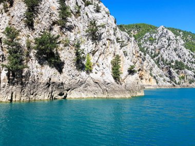 Güneşli, bulutsuz bir günde, dağların arka planına karşı deniz manzarası.