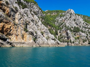 Güneşli, bulutsuz bir günde, dağların arka planına karşı deniz manzarası.