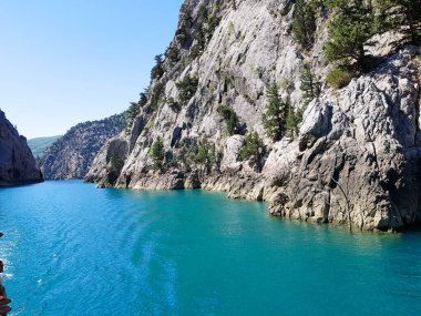 Güneşli, bulutsuz bir günde, dağların arka planına karşı deniz manzarası.