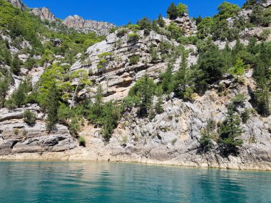 Güneşli, bulutsuz bir günde, dağların arka planına karşı deniz manzarası.