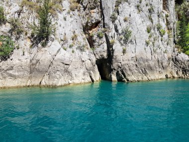 Güneşli, bulutsuz bir günde, dağların arka planına karşı deniz manzarası.
