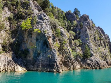 Güneşli, bulutsuz bir günde, dağların arka planına karşı deniz manzarası.