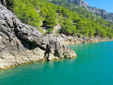 Güneşli, bulutsuz bir günde, dağların arka planına karşı deniz manzarası.