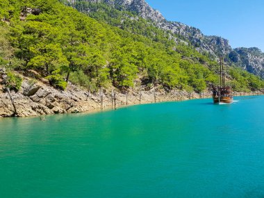 Güneşli, bulutsuz bir günde, dağların arka planına karşı deniz manzarası.