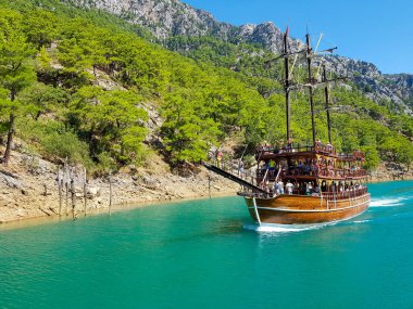 Güneşli, bulutsuz bir günde, dağların arka planına karşı deniz manzarası.