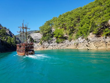 Güneşli, bulutsuz bir günde, dağların arka planına karşı deniz manzarası.