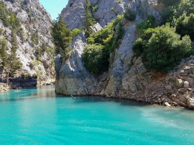 Güneşli, bulutsuz bir günde, dağların arka planına karşı deniz manzarası.