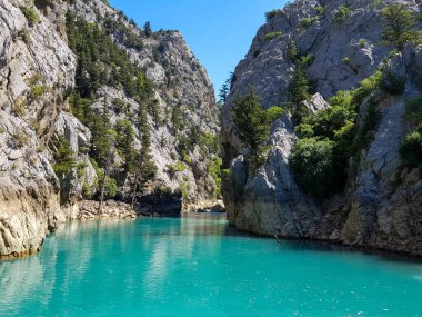 Güneşli, bulutsuz bir günde, dağların arka planına karşı deniz manzarası.