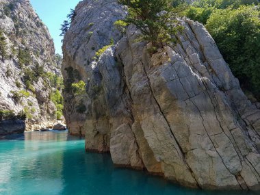 Güneşli, bulutsuz bir günde, dağların arka planına karşı deniz manzarası.