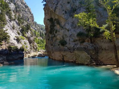 Güneşli, bulutsuz bir günde, dağların arka planına karşı deniz manzarası.