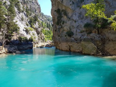 Güneşli, bulutsuz bir günde, dağların arka planına karşı deniz manzarası.