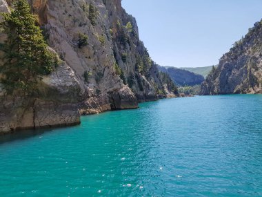 Güneşli, bulutsuz bir günde, dağların arka planına karşı deniz manzarası.