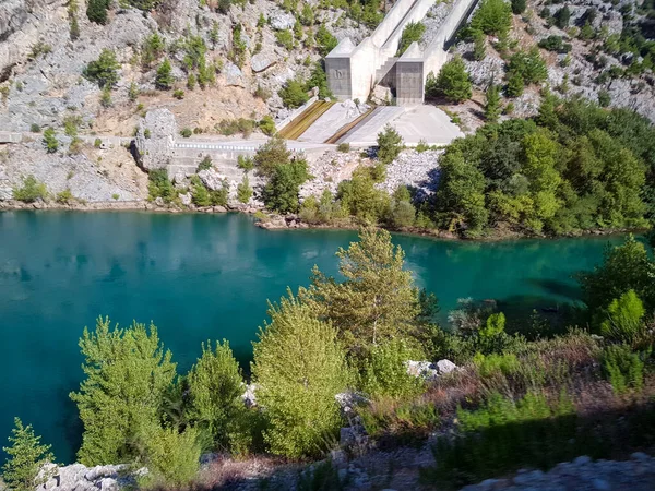 Güneşli, bulutsuz bir günde, dağların arka planına karşı deniz manzarası.