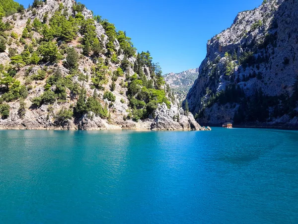 Güneşli, bulutsuz bir günde, dağların arka planına karşı deniz manzarası.