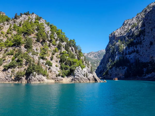 Güneşli, bulutsuz bir günde, dağların arka planına karşı deniz manzarası.