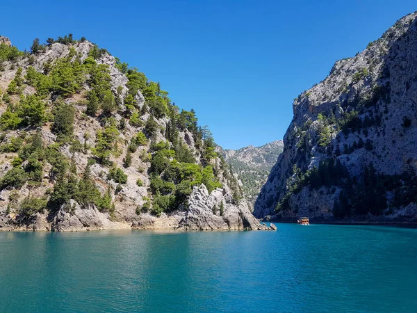 Güneşli, bulutsuz bir günde, dağların arka planına karşı deniz manzarası.