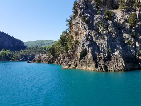 Güneşli, bulutsuz bir günde, dağların arka planına karşı deniz manzarası.