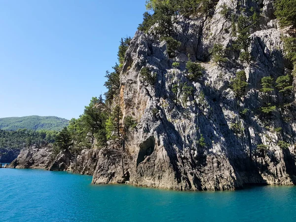 Güneşli, bulutsuz bir günde, dağların arka planına karşı deniz manzarası.