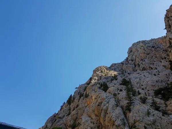 Güneşli, bulutsuz bir günde, dağların arka planına karşı deniz manzarası.