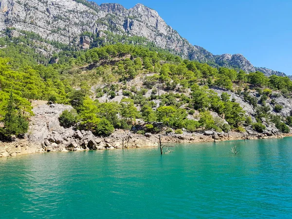 Güneşli, bulutsuz bir günde, dağların arka planına karşı deniz manzarası.
