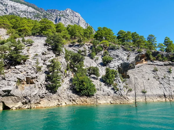 Güneşli, bulutsuz bir günde, dağların arka planına karşı deniz manzarası.