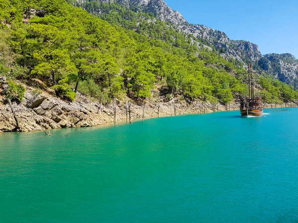 Güneşli, bulutsuz bir günde, dağların arka planına karşı deniz manzarası.