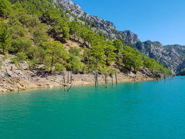 Güneşli, bulutsuz bir günde, dağların arka planına karşı deniz manzarası.