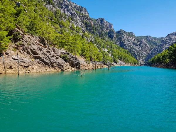 Güneşli, bulutsuz bir günde, dağların arka planına karşı deniz manzarası.