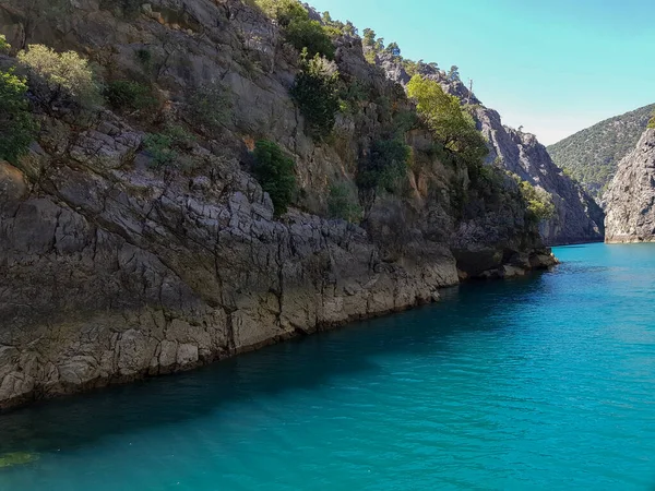 Güneşli, bulutsuz bir günde, dağların arka planına karşı deniz manzarası.