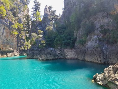 Güneşli, bulutsuz bir günde, dağların arka planına karşı deniz manzarası.