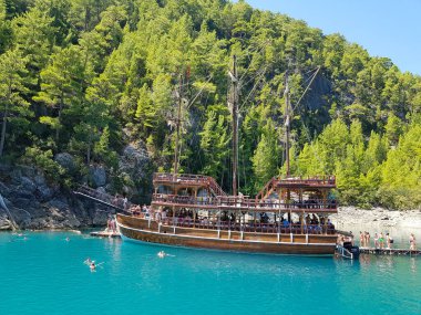 Güneşli, bulutsuz bir günde, dağların arka planına karşı deniz manzarası.