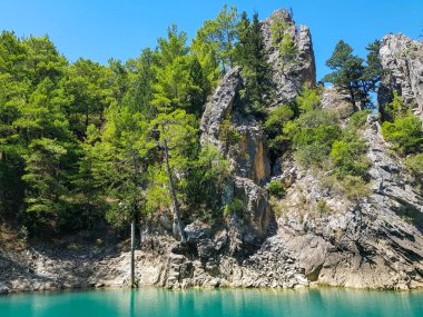 Güneşli, bulutsuz bir günde, dağların arka planına karşı deniz manzarası.