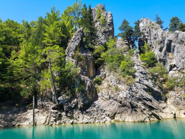 Güneşli, bulutsuz bir günde, dağların arka planına karşı deniz manzarası.