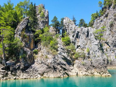 Güneşli, bulutsuz bir günde, dağların arka planına karşı deniz manzarası.