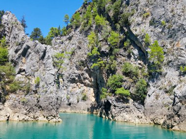 Güneşli, bulutsuz bir günde, dağların arka planına karşı deniz manzarası.