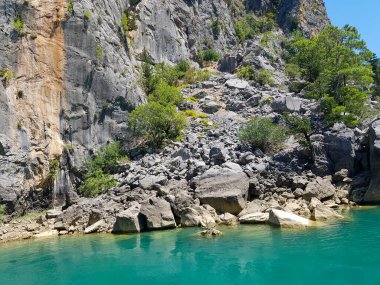Güneşli, bulutsuz bir günde, dağların arka planına karşı deniz manzarası.