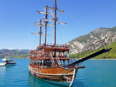 Güneşli, bulutsuz bir günde, dağların arka planına karşı deniz manzarası.