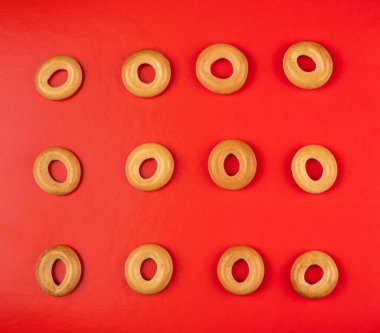 Kırmızı arkaplanda en üstteki görünümde çörekler veya simit