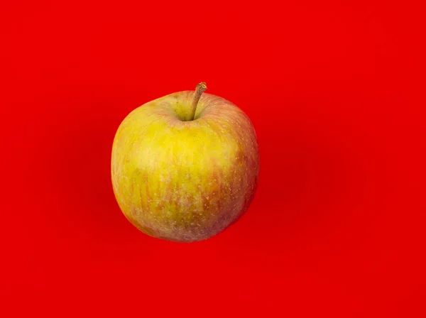 Свежее красное яблоко на красном фоне. — стоковое фото