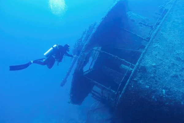 人类潜水者在蓝色深水中的沉船附近游泳 Thistlegormm号沉船 埃及红海 — 图库照片