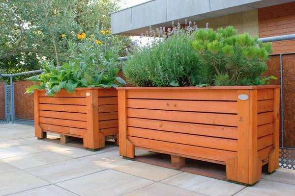 The large wooden flower containers on the terrace (pallet furniture)