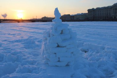 Büyük bir şehirde donmuş bir nehirde kar piramidinin yakın çekimi.