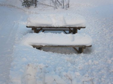 Masaya yakın çekim ve karın altındaki banklar. 